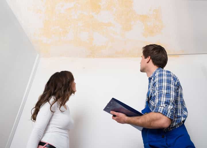 A water damage expert doing an assessment and inspection with a woman who has damaged ceiling caused by a water leak in Bowling Green, KY